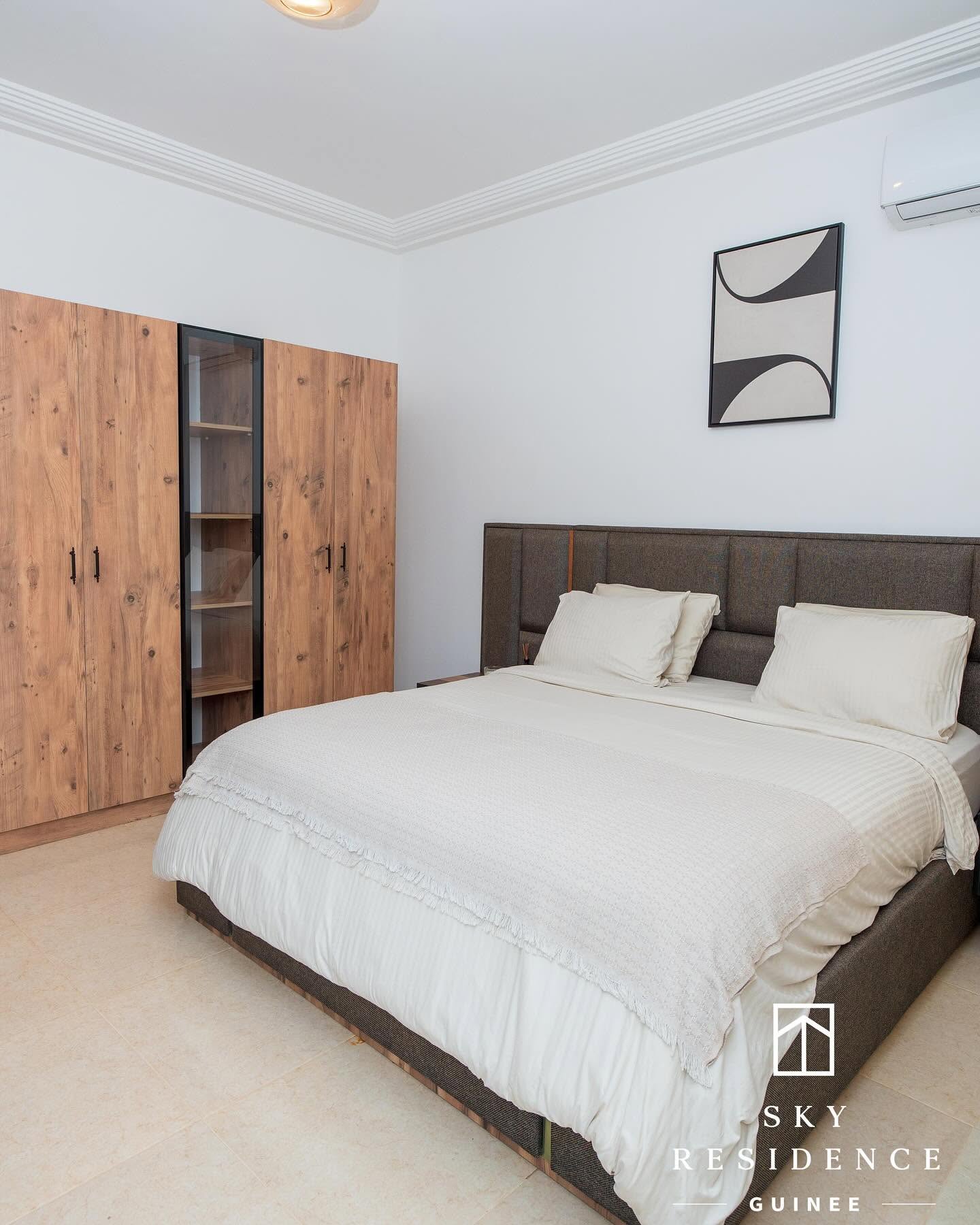 Chambre avec dressing en bois et literie ivoire