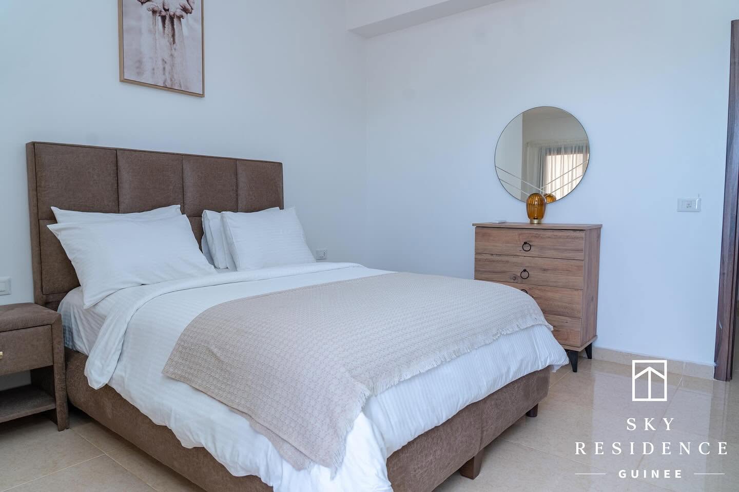 Chambre lumineuse avec commode et miroir rond